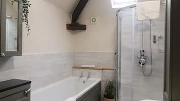 A modern bathroom with a bathtub, toilet, shower, and sink.