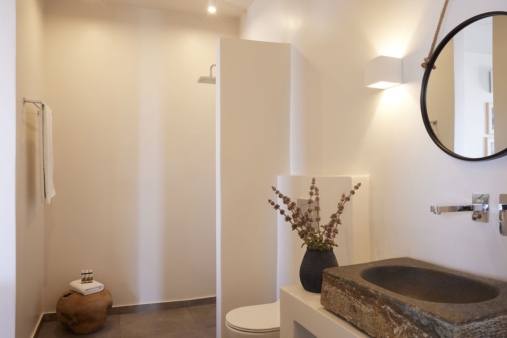 A modern bathroom with a shower, toilet, and sink.