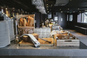 A buffet setup with bread, pastries, and glasses. - Langley Hotel Victors (Val-d'Isere)