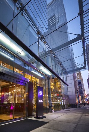 A modern building with large glass windows and a prominent RII sign. - Hotel Riu Plaza New York Times Square (New York)
