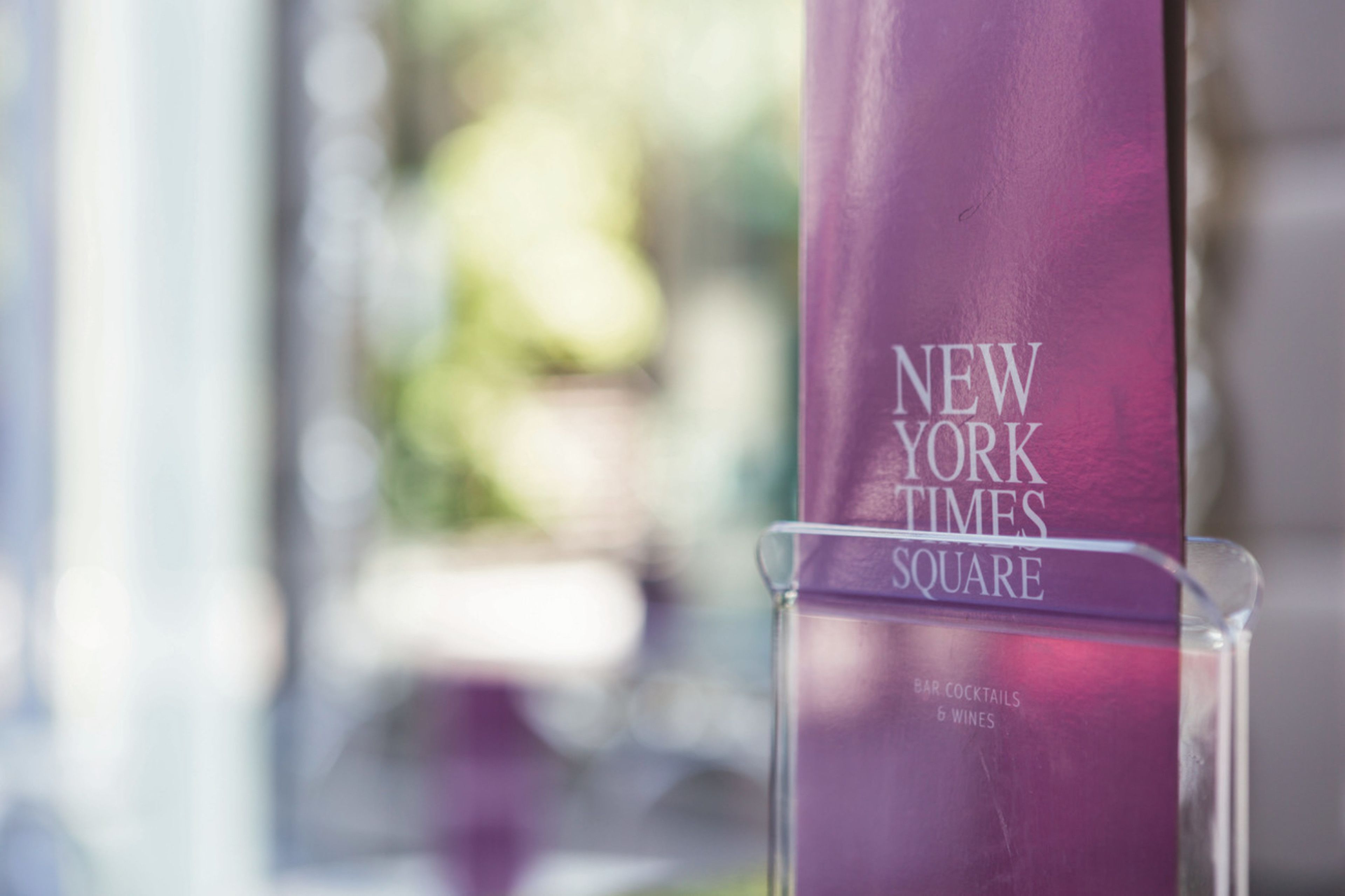 A purple bottle with the text "NEW YORK TIMES SQUARE" and "BAR COCKTAILS 6 WINES" visible.