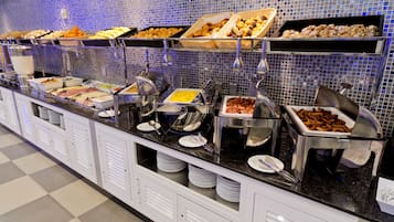 A buffet with various food items and utensils.