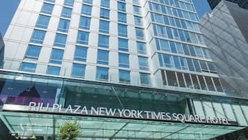The exterior of the Riu Plaza New York Times Square Hotel with a clear view of its modern glass facade and the entrance.