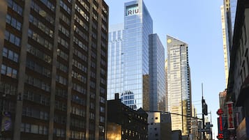 A cityscape with tall buildings, including a prominent glass skyscraper with 'RIU' on top.
