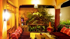 A cozy interior with a sofa, a table, and a bookshelf. - Ahadi Lodge (Arusha)