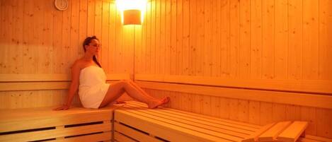 A sauna with wooden benches and a wall-mounted light fixture.