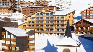 Un edificio cubierto de nieve con varios balcones y una torre destacada.