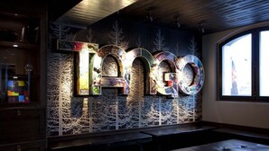 Un interior moderno con una instalación artística mural que deletrea 'Tango'.
