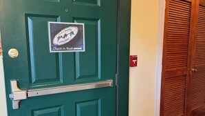 Una puerta verde con un letrero de recepción, un picaporte metálico y un timbre.