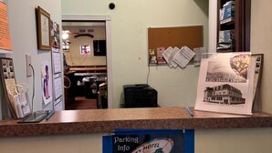 Un mostrador de recepción de hotel con un cartel que indica estacionamiento gratuito en la parte trasera.