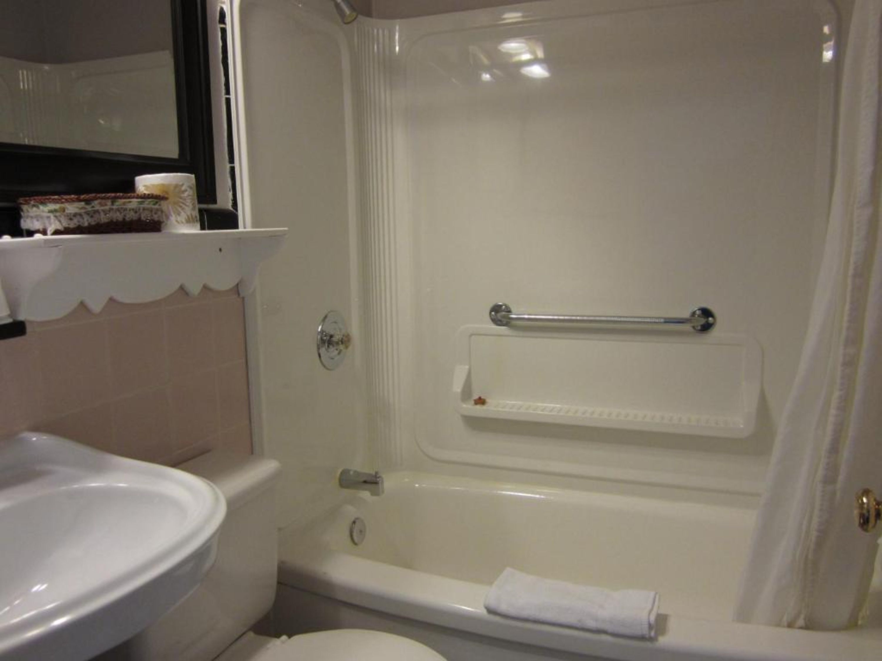 Baño con lavamanos, inodoro, bañera y toallero.