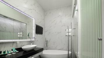 A modern bathroom with a large mirror, a white sink, and a freestanding bathtub.