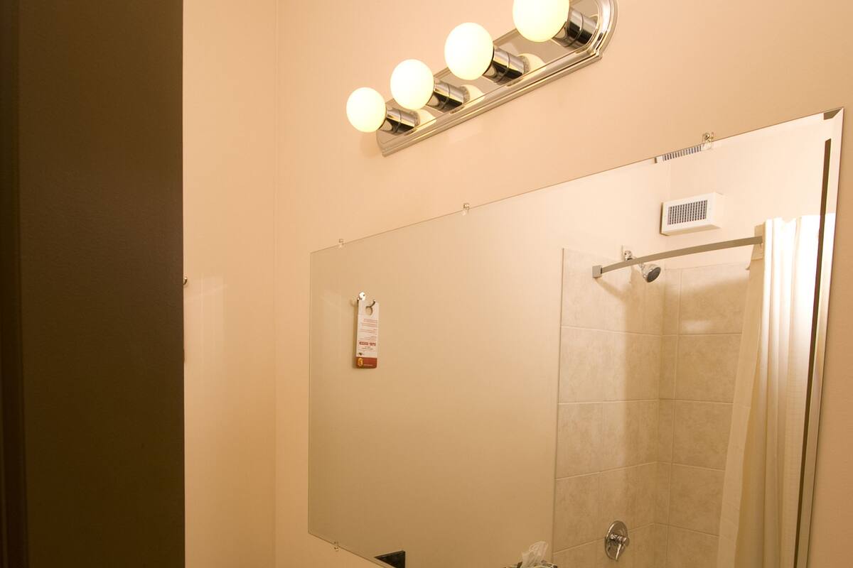 Un baño con lavabo, espejo y ducha.