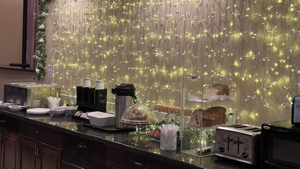 Una barra de desayuno con una pared decorativa, una máquina de café y un tostador.