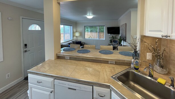 A modern kitchen with a central island, built-in appliances, and a large window providing natural light. - Arctic Fox Inn (Anchorage)