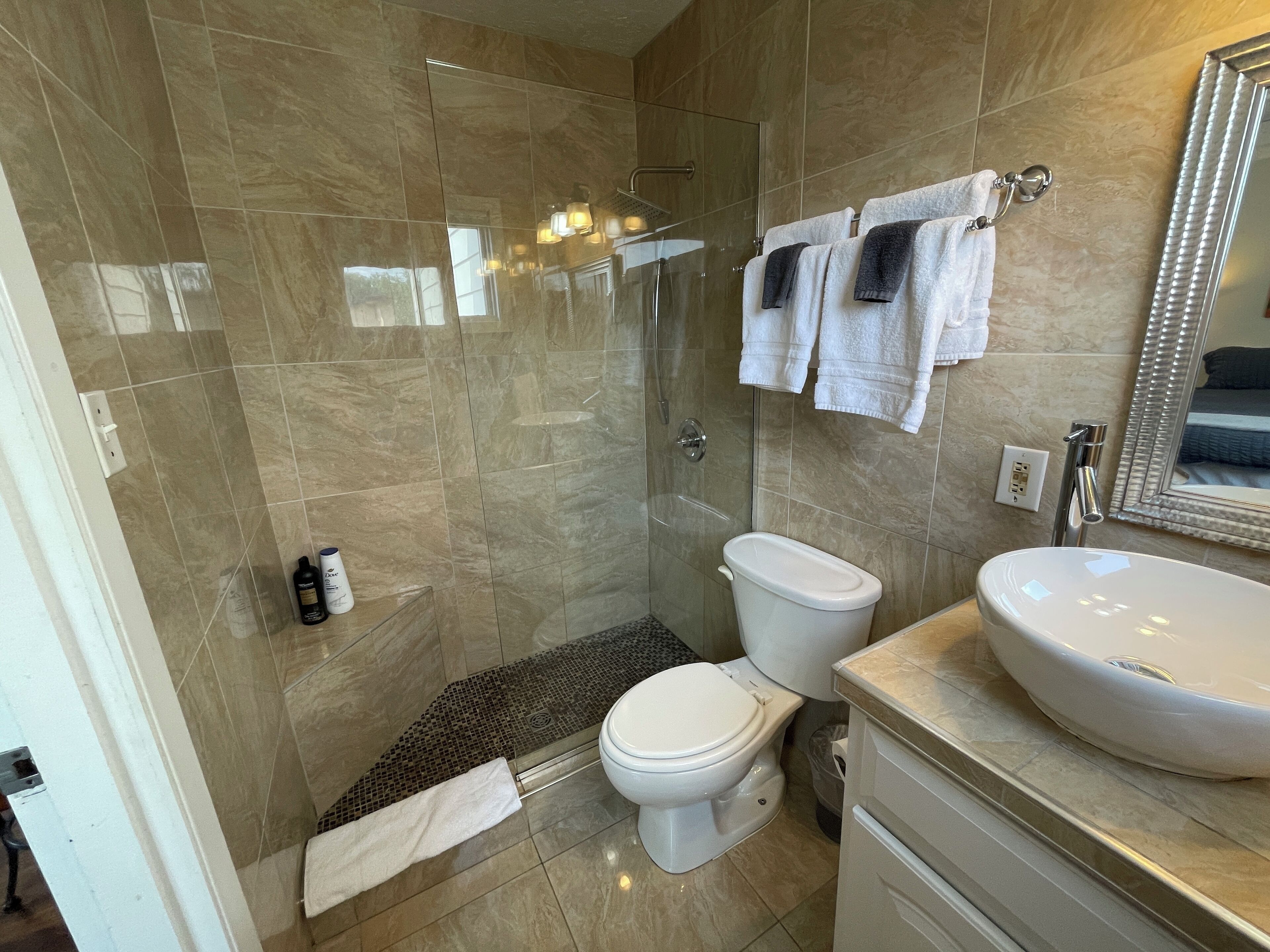 Une salle de bain moderne avec une douche à parois de verre, des toilettes et un lavabo.