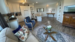 A compact living space with a kitchenette, a dining area, and a seating area with a TV. - Arctic Fox Inn (Anchorage)