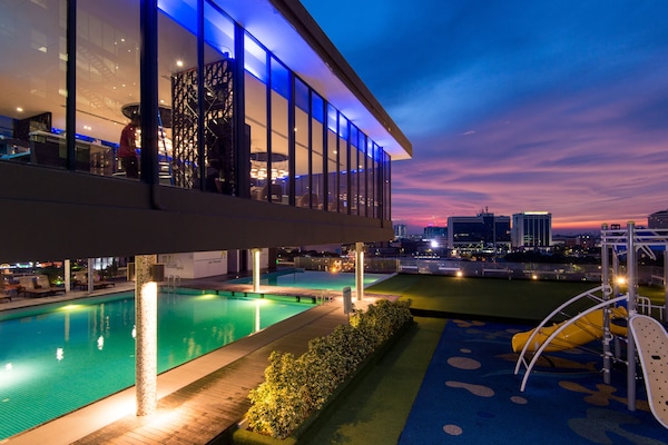 Una piscina al aire libre, sillones reclinables de piscina