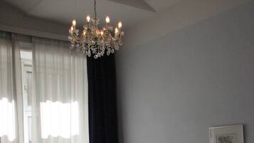 Una habitación de hotel con una cama grande, un escritorio con una silla, una lámpara y un candelabro.