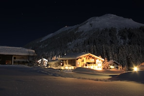 A snow-covered mountain with a lodge in the foreground. - Pension Daniel (Lech am Arlberg)