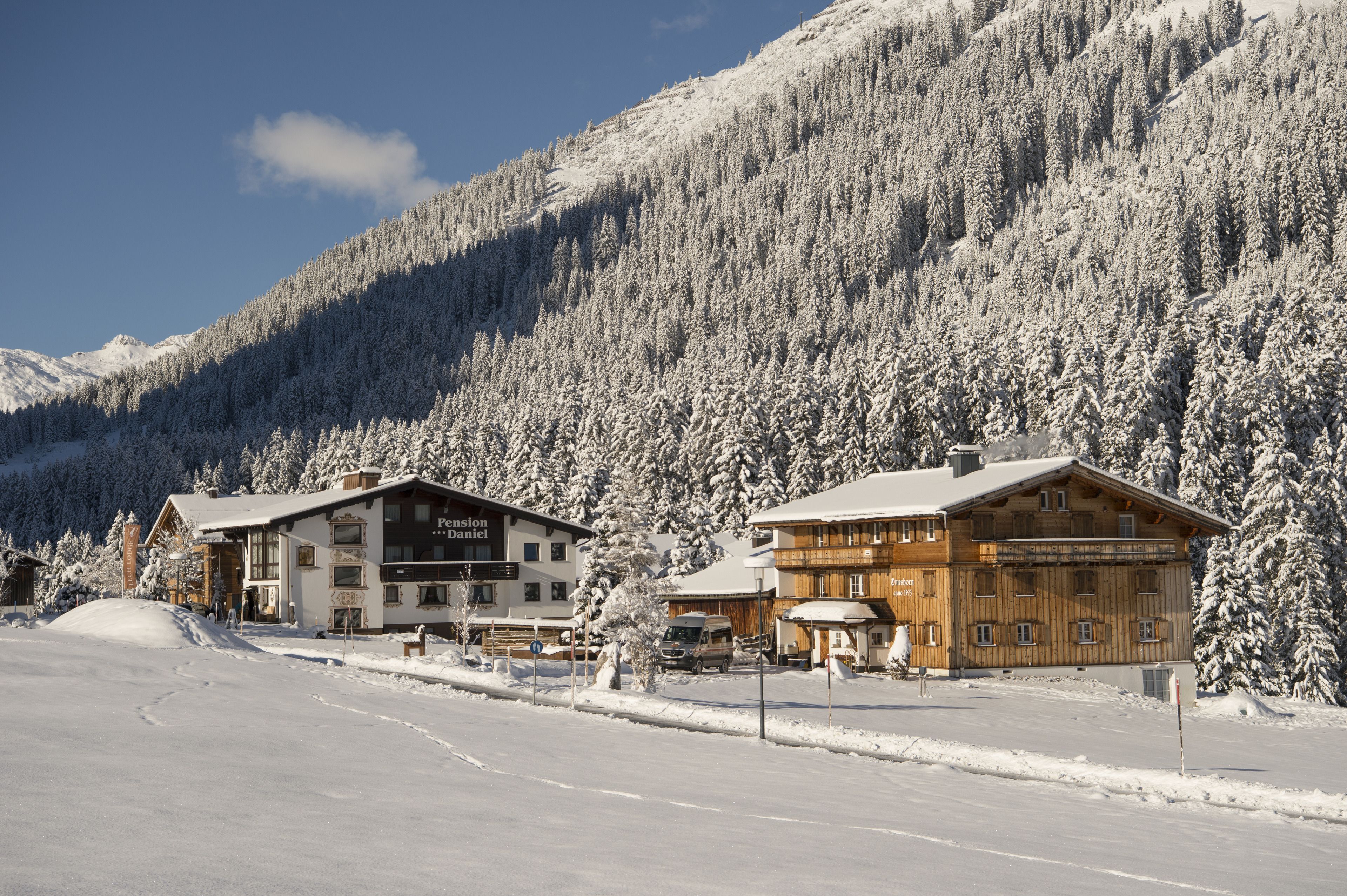 A snow-covered mountain with a building complex featuring a restaurant and lodging.
