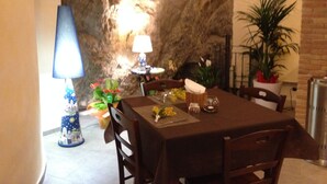 A dining area with a table set for two, a lamp, and a potted plant. - Locanda Del Drago (Monreale)