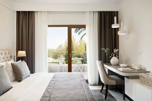 A modern hotel room with a large bed, a desk, and a balcony with outdoor furniture.