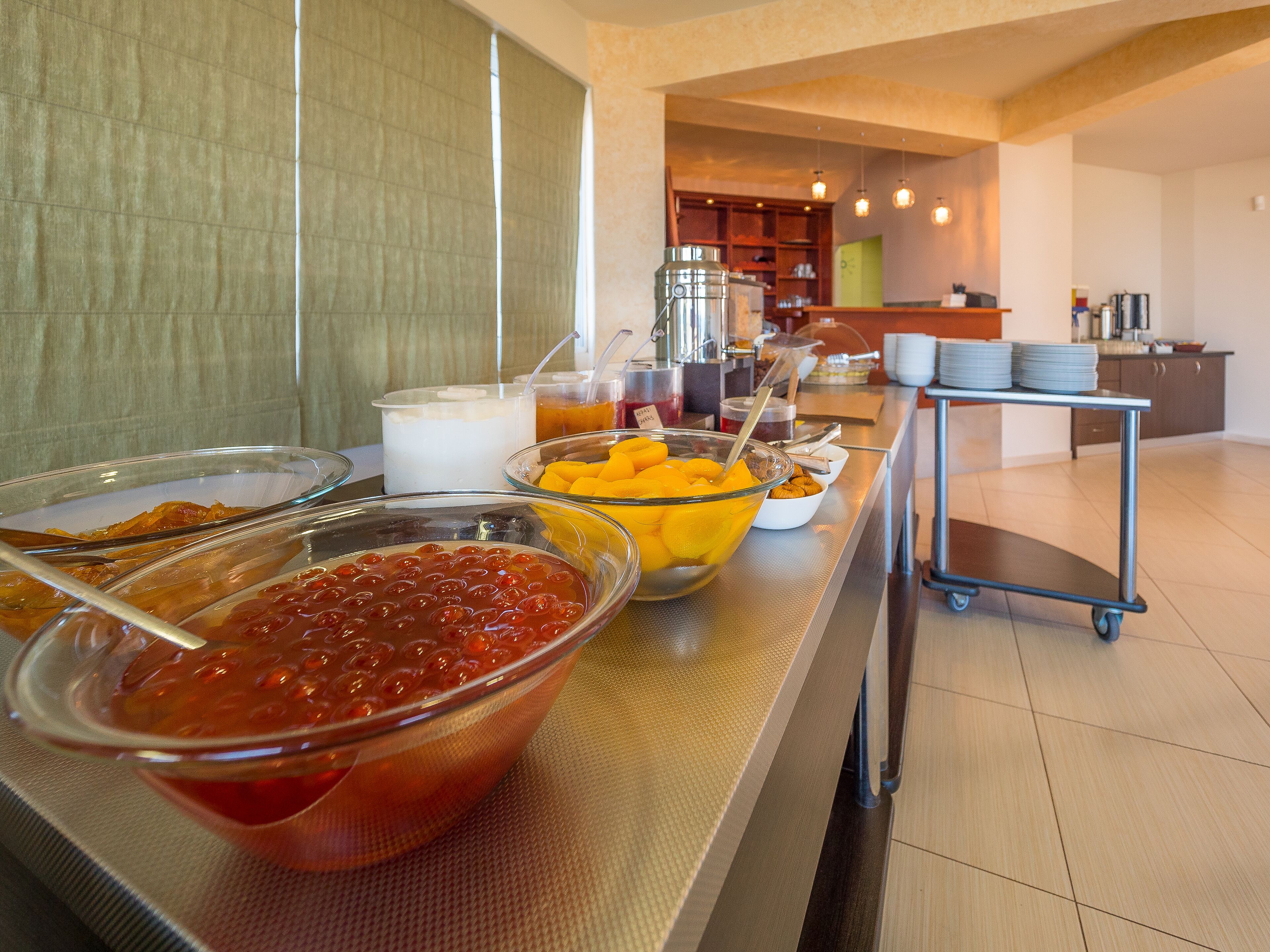 Un buffet con diversi piatti e un carrello in una cucina moderna.