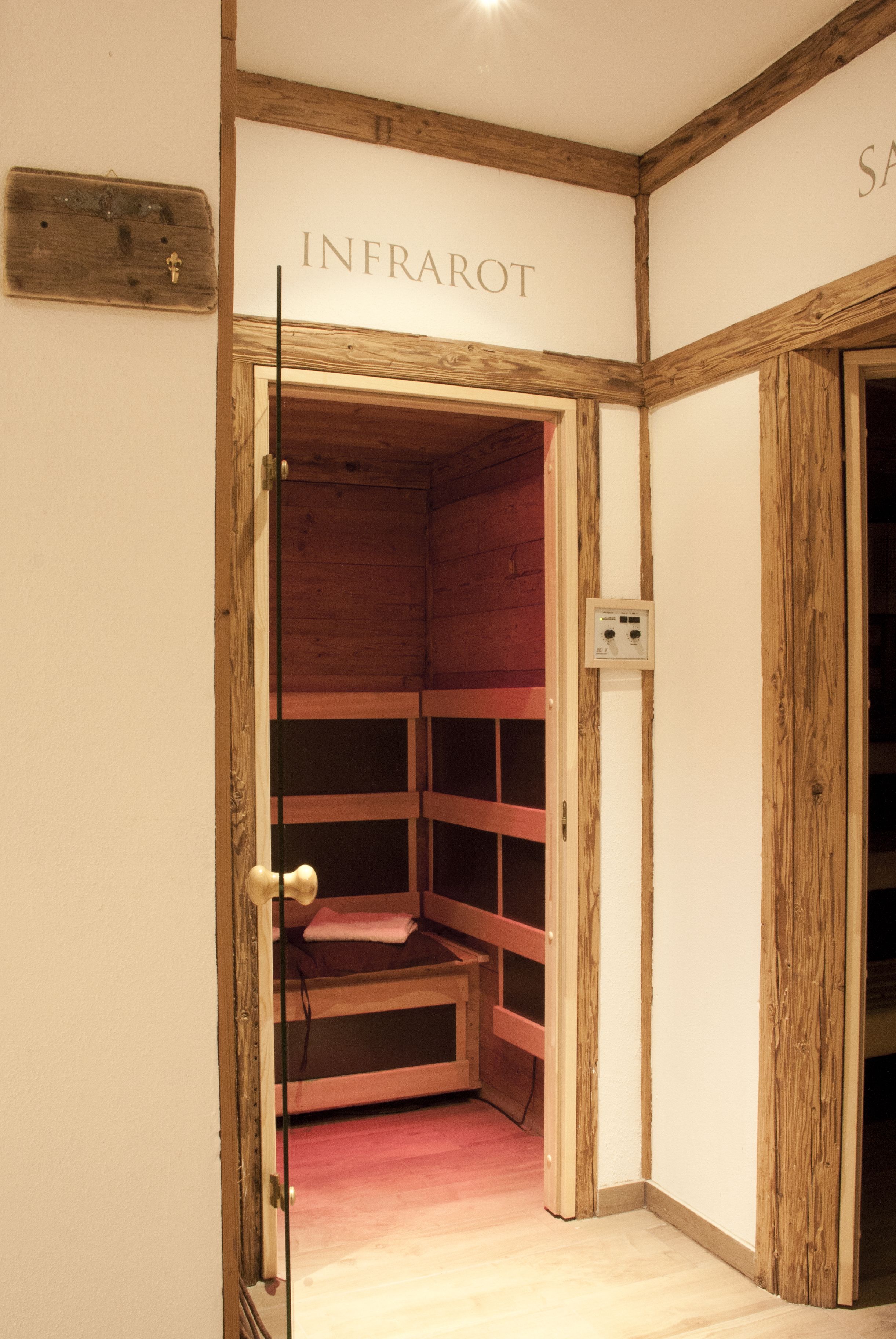 A room with a wooden bench and a wall-mounted electrical outlet.