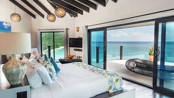 Un dormitorio con una cama grande, un televisor y vistas al océano.
