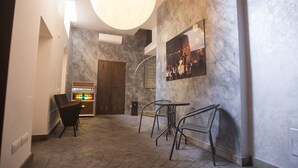 A modern lobby with a marble floor, a large round light fixture, a piano, and a seating area with metal chairs and tables. -  Gueshouse o Affitacamere Magenta Campo dei Fiori  (Rome)