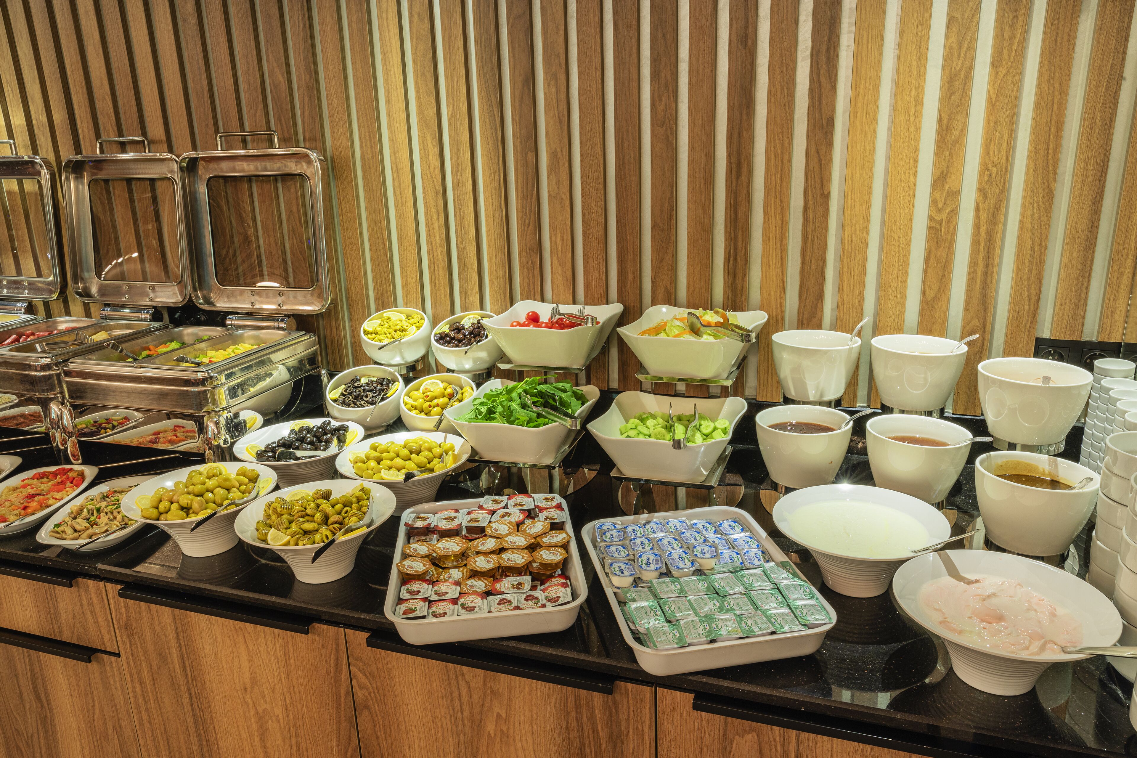 A buffet with various food items and containers.