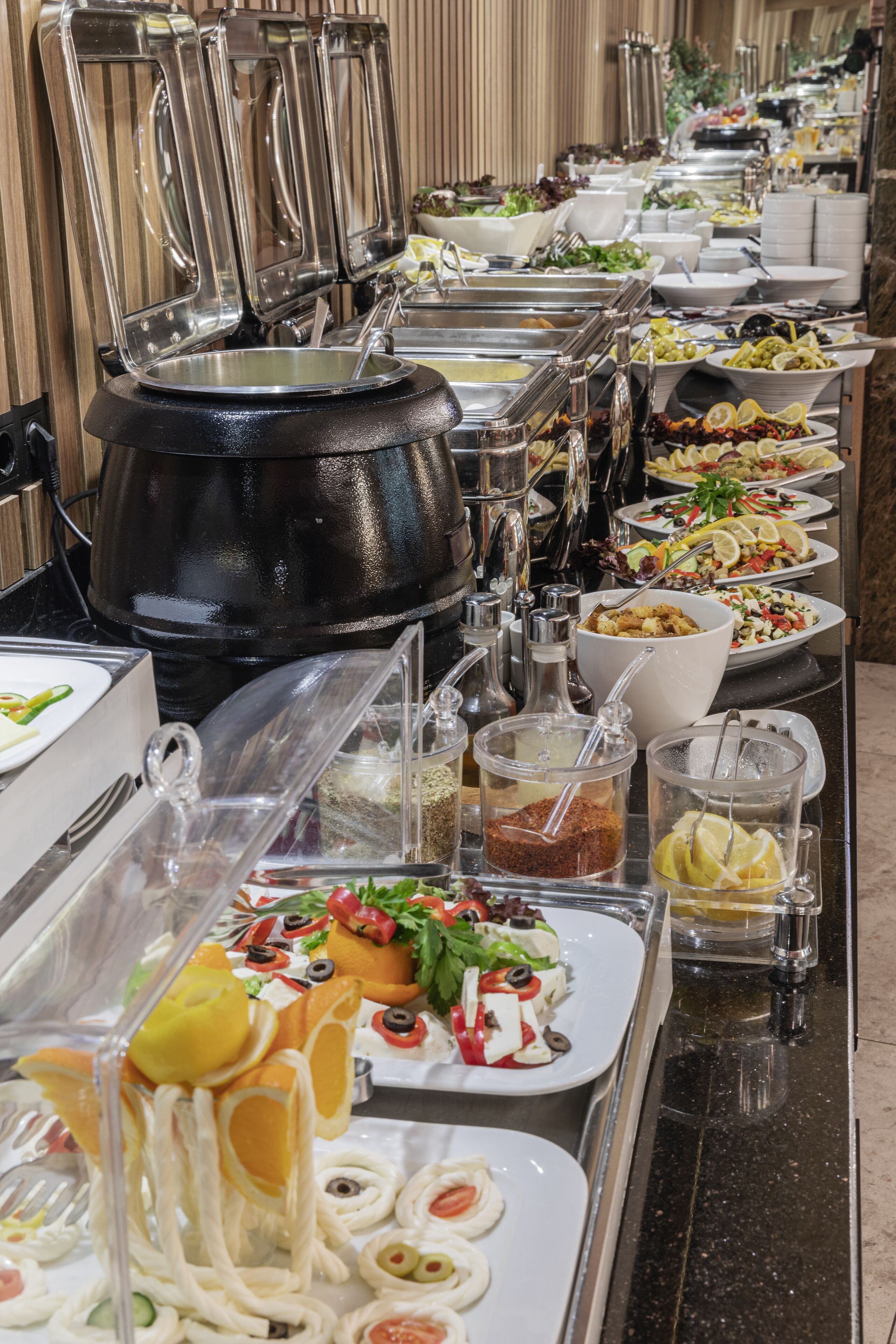 A buffet with various food stations and utensils.