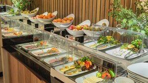 A buffet with various food items and a wooden wall in the background. - Ayramin Deluxe Hotel  (Istanbul)