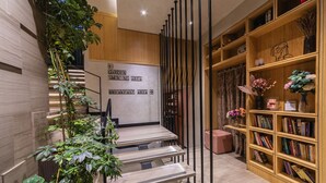 A modern interior with a staircase, a bookshelf, and a sign indicating different areas. - Ayramin Deluxe Hotel  (Istanbul)