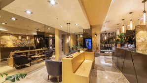 A modern hotel lobby with a reception desk, seating area, and a large mirror. - Ayramin Deluxe Hotel  (Istanbul)