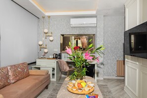 A modern living room with a sofa, dining table, and a TV.
