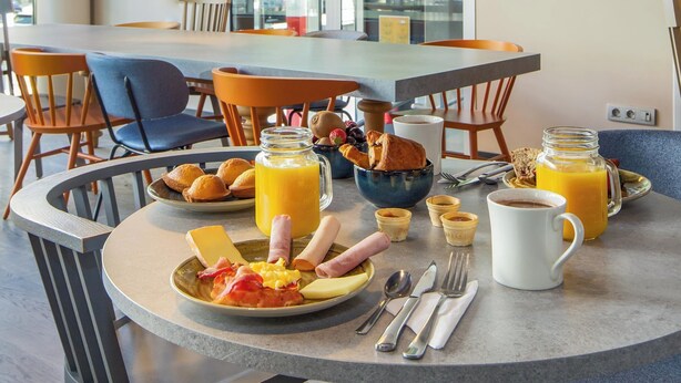 Une table de petit-déjeuner avec une table, des chaises et un tableau encadré accroché au mur.