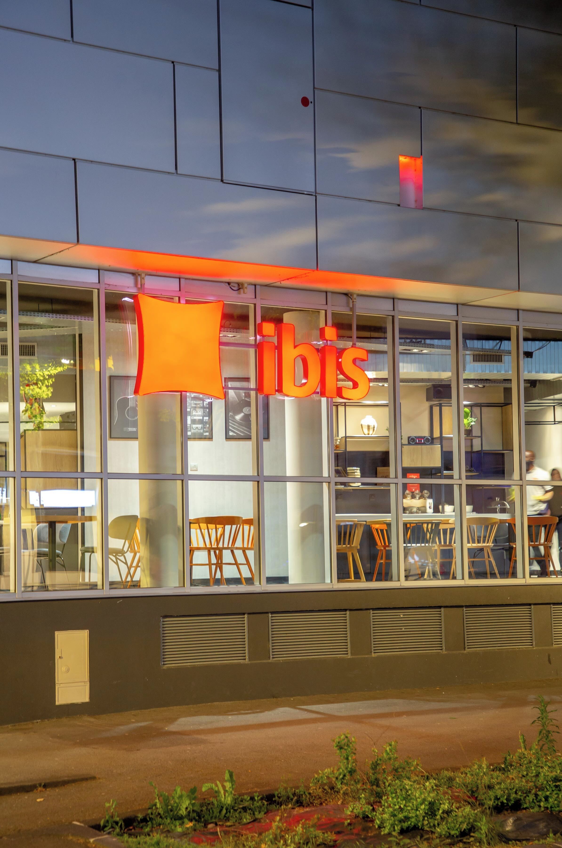 A building with a large glass facade, a prominent 'bis' sign, and interior seating visible through the windows.