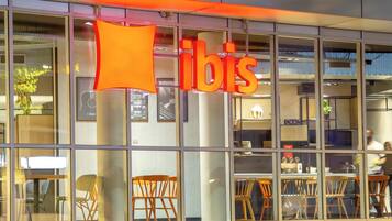 A building with a large glass facade, a prominent 'bis' sign, and interior seating visible through the windows.