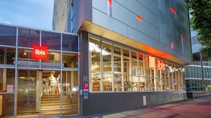 Un bâtiment moderne avec de grandes fenêtres en verre et le logo « ibis ».