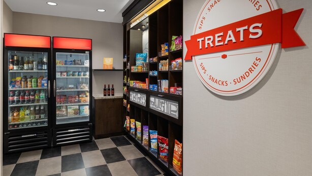 Zona de venta de bebidas con dos refrigeradores y un cartel que indica aperitivos.