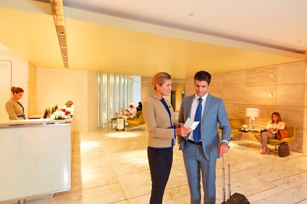 A hotel lobby with a reception desk, seating areas, and a modern interior design. - Oryx Airport Hotel (Doha)