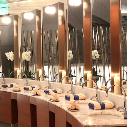 A modern bathroom with multiple sinks, mirrors, and candles.