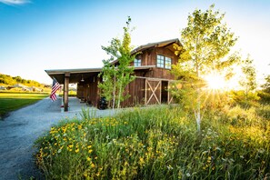 Guests can enjoy a welcoming porch area surrounded by a well-maintained lawn and wildflowers.