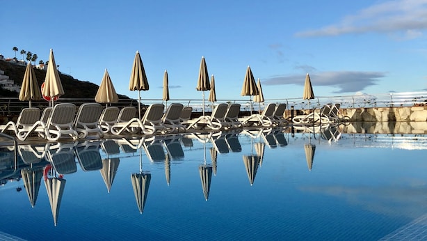 A clear blue sky with a calm pool reflecting the surroundings. - Holiday Club Sol Amadores (Mogan)