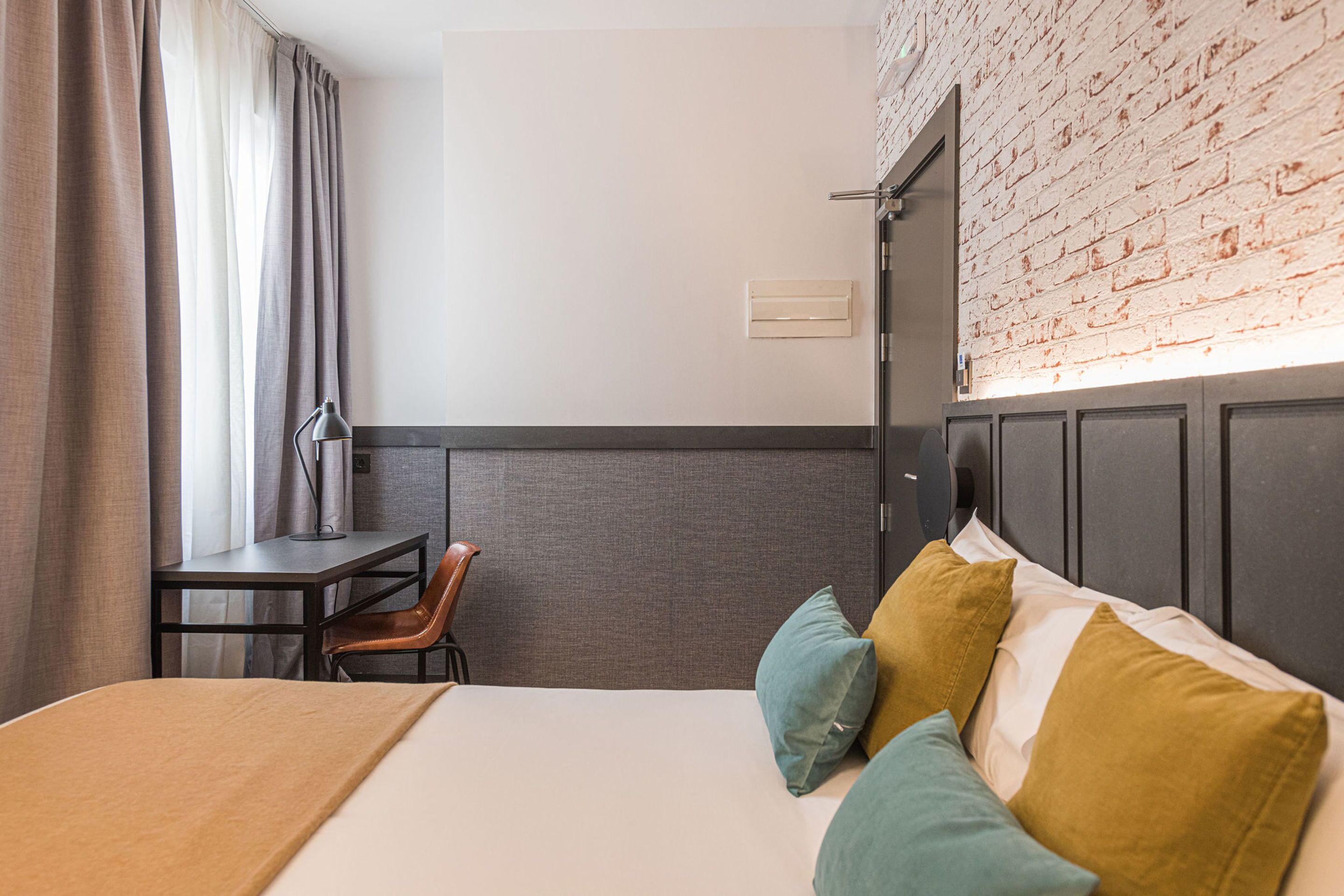 Habitación de hotel con una cama, un escritorio y una silla.
