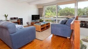 Ein modernes Wohnzimmer mit zwei Sofas, einem Couchtisch und einem Fernseher.