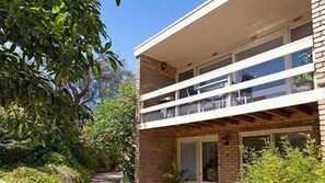 A two-story building with a balcony, surrounded by greenery. - Bayside St Johns Close (Blairgowrie)