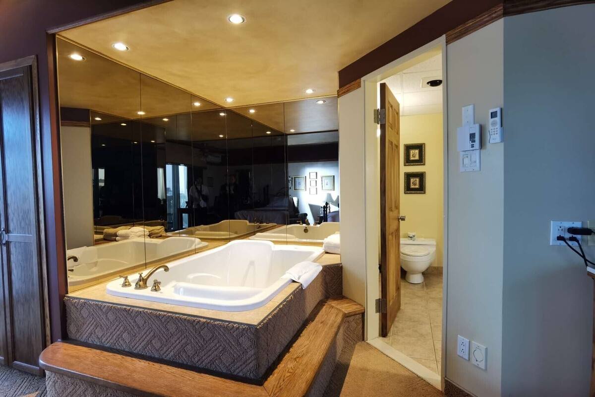 A modern bathroom with a large freestanding bathtub, a separate shower area, and a toilet.